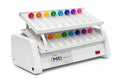 A white scientific tube rocker with two angled racks holding clear plastic tubes, each fitted with a brightly colored cap in red, orange, yellow, green, blue, purple, and pink. The front panel shows the logo 'MPD SCIENTIFIC' and a red power switch.